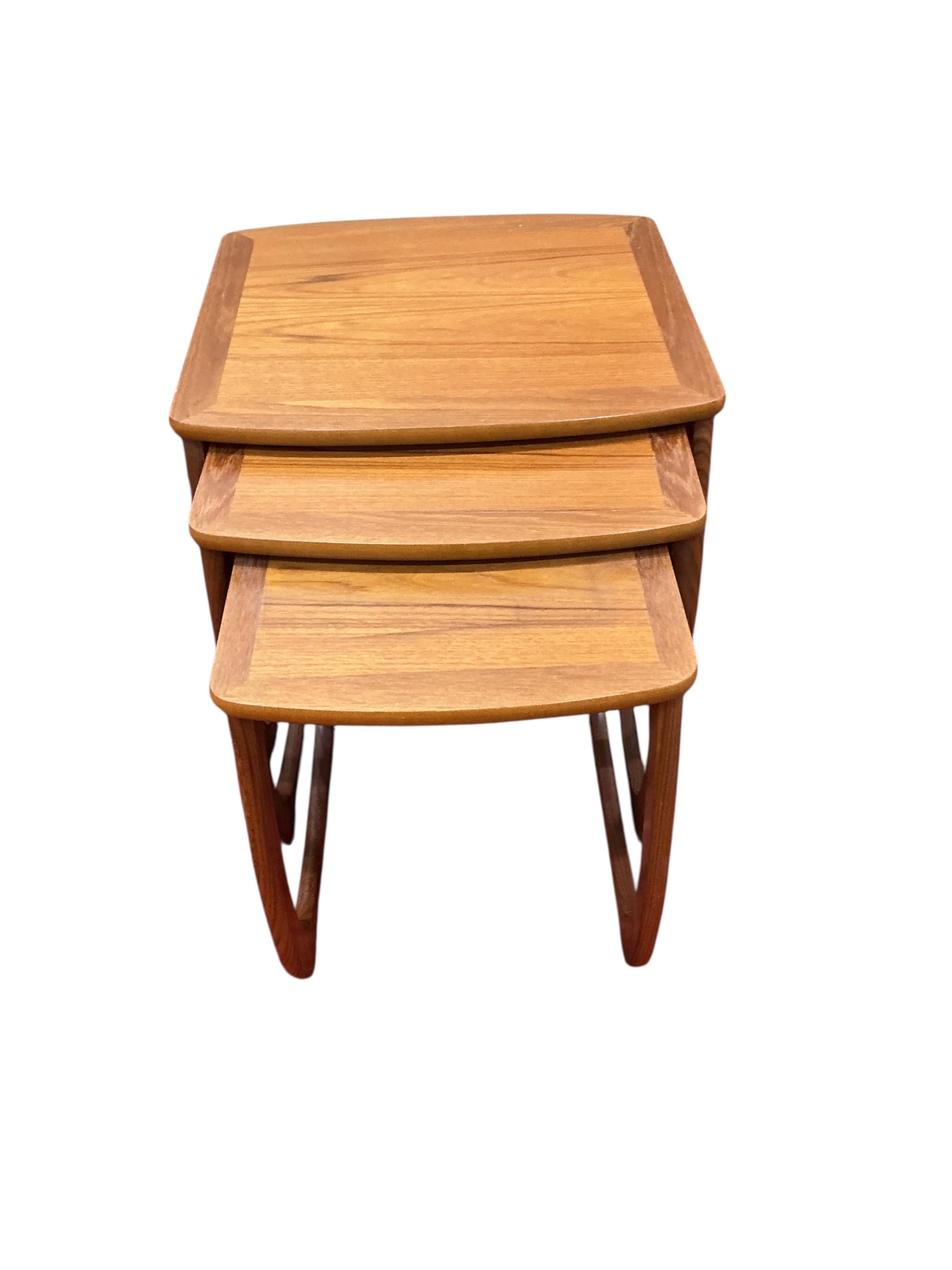 A nest of three mid century Nathan teak tea tables, width 52cm, depth 48cm, height 50cm together with a mid century teak coffee table